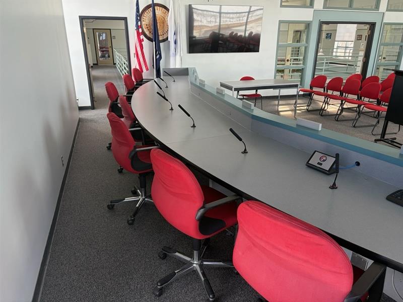 In this blog post about how Smart Offices is Supporting Michigan Agencies Through the MiDEAL Program, we see a city council chamber that has been equipped with television displays, microphones and a touch-screen control panel for managing video conference meetings.